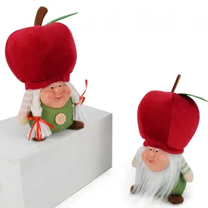 Detailed shot of two festive apple gnomes set against a clean white background.