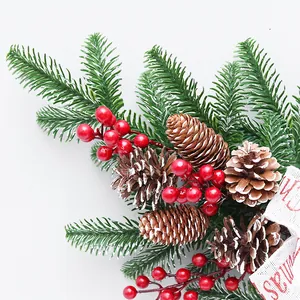 Christmas pine branch wreath decoration featuring red berries, pine cones and festive ribbon