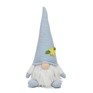 Detail view of a spring Easter gnome plush with light blue hat and yellow flower