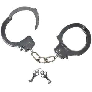 Detailed macro shot of realistic metal toy handcuffs and keys for police role-playing outfits