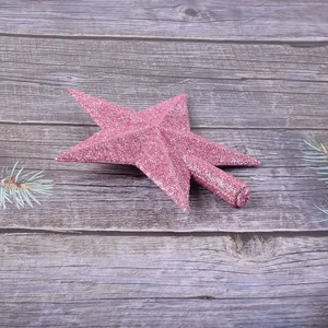 Gros plan de l'étoile de sapin de Noël rose pailletée sur fond de bois