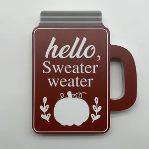 Détail d'une plaque en bois en forme de bocal avec un motif de citrouille et texte d'automne