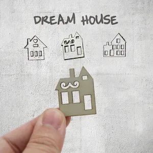 Close-up of a laser-cut wooden house ornament for DIY Christmas crafts and decor