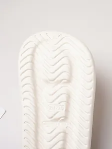 Macro detail showing the anti-slip wavy traction pattern on white comfortable slides outsole