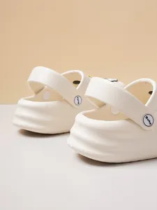 Detail of white comfortable clogs with swivel heel strap and wave sole pattern.