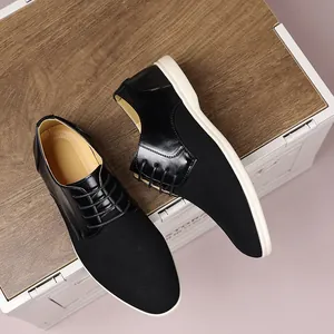 Primo piano di scarpe casual da uomo in pelle scamosciata e pelle nera su fondo in legno.