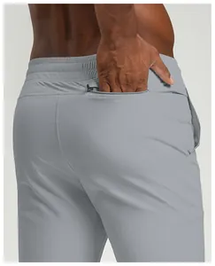 Detailed view of the zippered back pocket on grey quick-dry men's sports joggers.