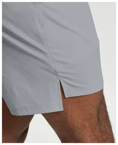Close-up of gray quick-dry sports shorts showing fabric texture and side slit detail.