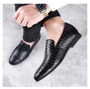 Close-up of black men's loafers with a classic woven texture and slip-on design on marble.