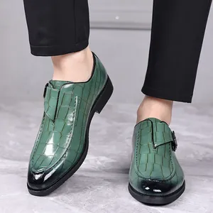 Detail van groene heren monk-schoenen van leer met krokodillenpatroon en gesp.