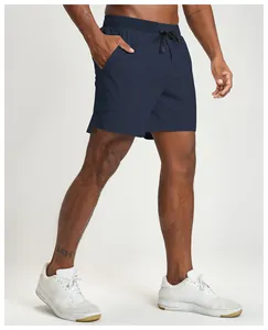 Detailed view of breathable navy blue sports shorts on a model wearing white sneakers