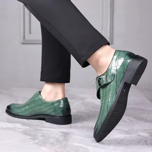 Detailweergave van groene herenmonkschoenen met krokodillenpatroon en gesp detail