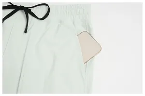 Close-up of deep side pocket on mint green quick-dry sports joggers with a phone