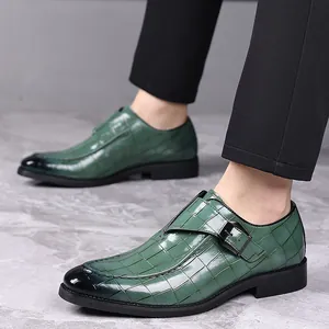 Detailweergave van groene herenmonkschoenen met krokodillenmotief, gesp en vierkante neus