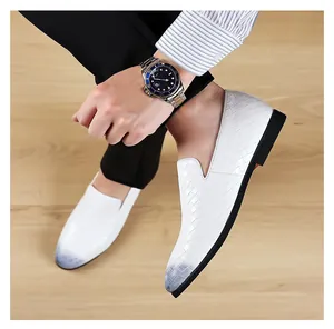 Close-up of elegant white embossed loafers with a grey gradient toe worn by model