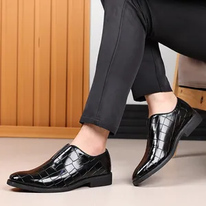 Primer plano de zapatos de vestir para hombre en cuero negro con patrón de cocodrilo