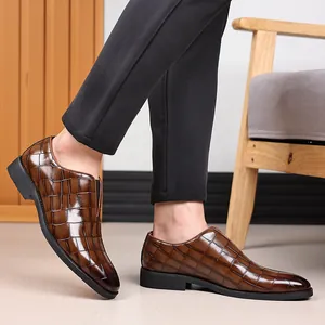 Detalle de zapatos de cuero marrón para hombre con patrón de cocodrilo