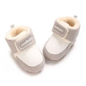 Paar gemütliche grau-weiße Plüsch-Babystiefel mit Klettverschluss für winterliche Wärme