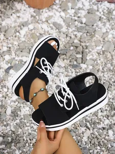 Close-up view of women's black platform lace-up sandals with thick white soles.