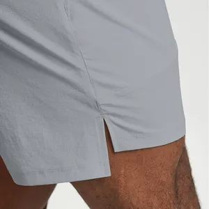 Close-up of gray recycled quick-dry men's tennis shorts showing fabric texture and side slit