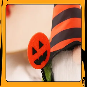 Macro detail of Halloween faceless gnome witch doll with striped hat and pumpkin