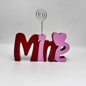 Primo piano di un cartello Mine in legno rosso e rosa con clip portafoto a cuore