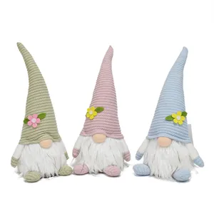 Three pastel Easter gnomes with knitted hats and white fur beards on white background