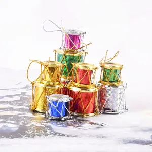Detalle de pequeños tambores navideños láser coloridos con hilos dorados brillantes y colgador
