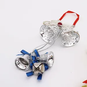 Detail showing silver Christmas bell pendants with elegant blue ribbons and red loops.