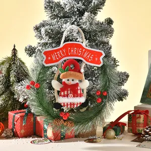 Detailed view of a mini Christmas pine wreath with a plush snowman figure decoration.