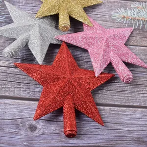 Vue détaillée des étoiles scintillantes pour cime de sapin de Noël en rouge, rose, argent et or