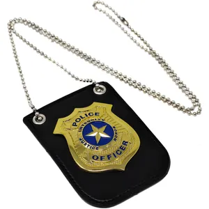 Close-up detail of a gold metal police badge on black leather holder with a ball chain.