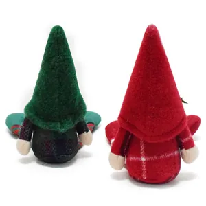 Rear view of two decorative plush Christmas gnomes sitting on white background