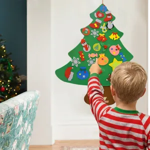 Child decorating a DIY felt Christmas tree with colorful ornaments on the wall