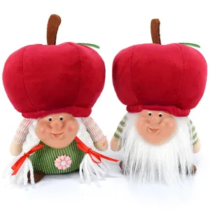 Pair of cute Christmas plush gnomes with oversized red apple hats and festive outfits.
