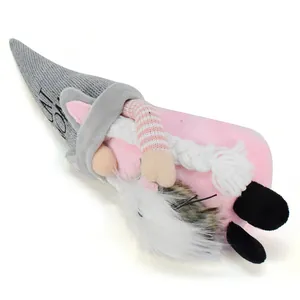 Detailed macro view of a cute plush cat gnome with knitted hat and pink body