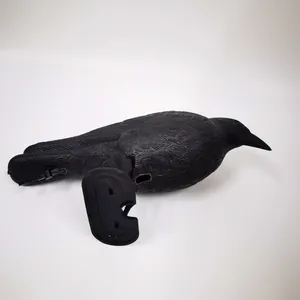 Detailed view of realistic black plastic crow decoy featuring a detachable garden stake