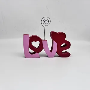Dettaglio dell'ornamento in legno 'Love' con portafoto in filo metallico per decorazioni