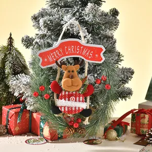 Detail of Christmas reindeer ornament hanging on frosted pine tree with gifts