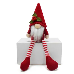 Close-up of a festive Christmas gnome plush with long striped legs and holly hat