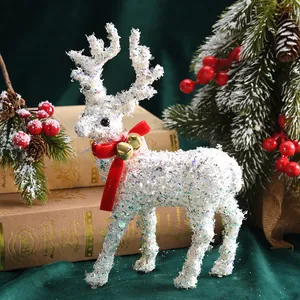 Weiße Weihnachts-Rentierfigur mit Glitzer, roter Schleife und goldenen Glocken.