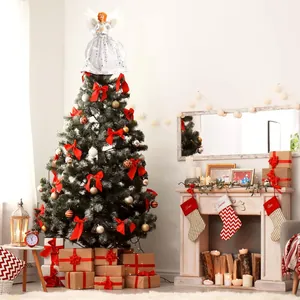 Detail showing a white angel tree topper placed on a decorated tree in a cozy living room