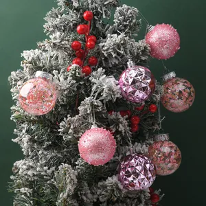 Assorted 6cm pink Christmas balls with glitter and faceted designs on snowy tree decor