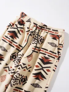 Detail view of plush fleece pants featuring a geometric tribal pattern and drawstring