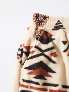 Close-up of men's fleece pants showing soft Sherpa texture and tribal geometric pattern.