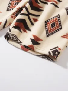 Nahaufnahme von Fleece mit Stammesmuster, weiche Textur und geometrische Druckdetails.