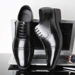 Professional black pointed-toe leather dress shoes with brogue wingtip details for men