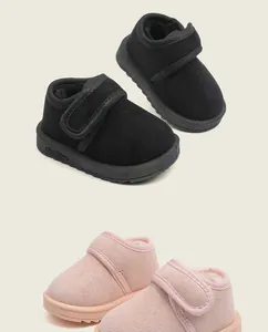 Close-up detail of warm infant snow boots in black and pink with soft fleece lining.