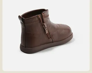 Vista detallada de botas de cuero marrón para niños con cremallera lateral funcional