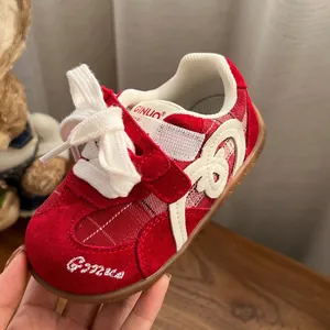 Macro detail of red toddler sneakers with soft sole and white embroidered Ginuo logo